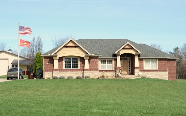 A modern brick house with a large green lawn