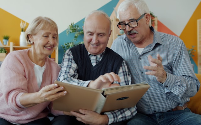 Older adults sitting together looking at an album