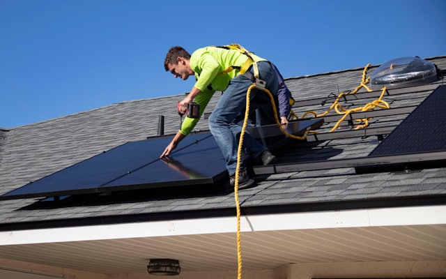An installer working on a rooftop solar array